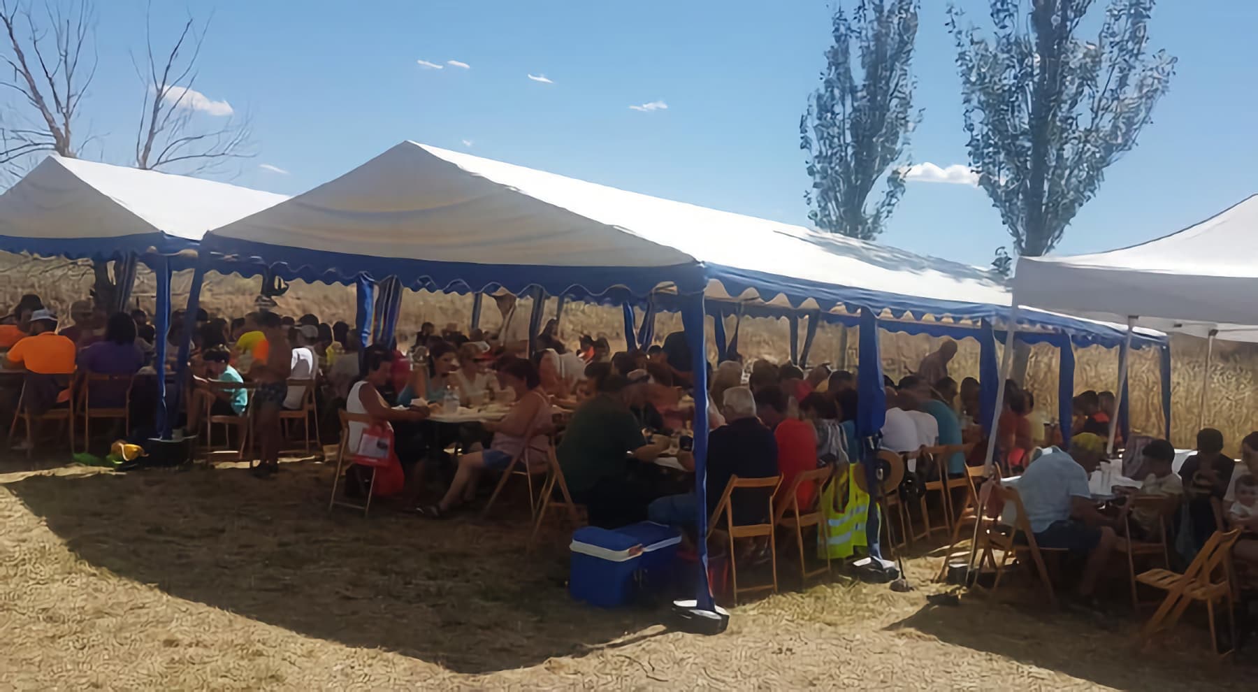 Participantes comiendo bajo carpas